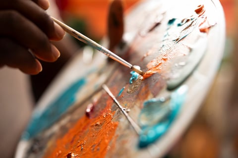Painter mixing watercolor paints on palette