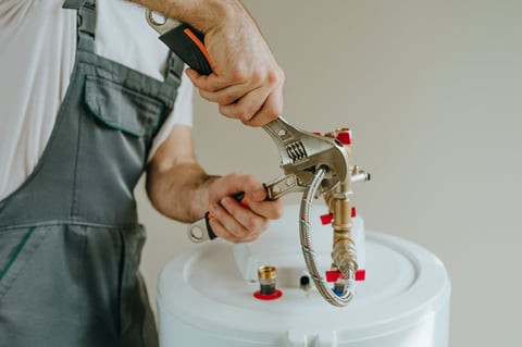 Man fixing water heater with wrench