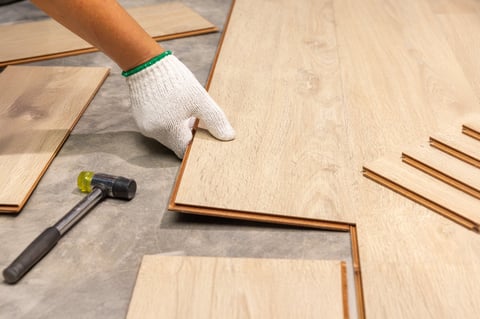 Worker installing interlocking laminate floor