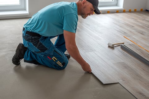 Floating floor work - worker inserts vinyl plank to click system