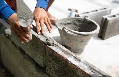 Hand worker masonry brickwork with trowel on construction site