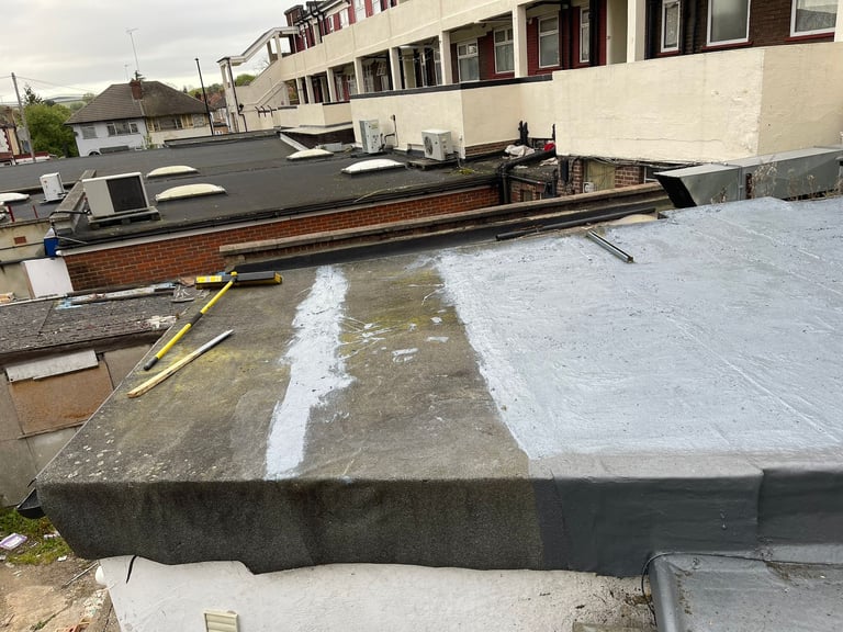 Commercial building roof under renovation with partially installed white membrane and exposed concrete sections