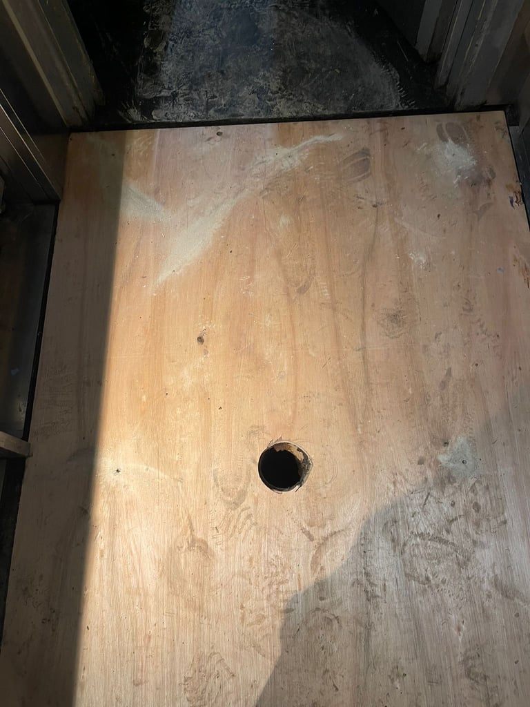 Top-down view of a weathered wooden surface with a single dark circular hole near the center